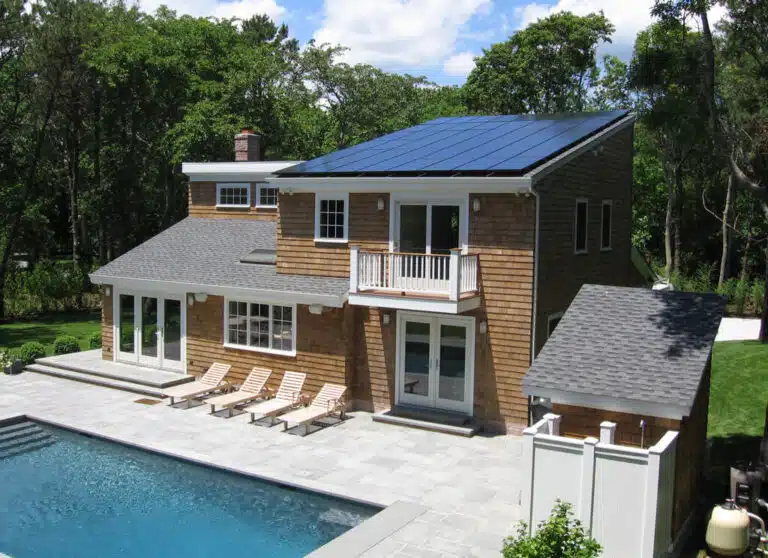 Solar panels installed on a rooftop with a big pool